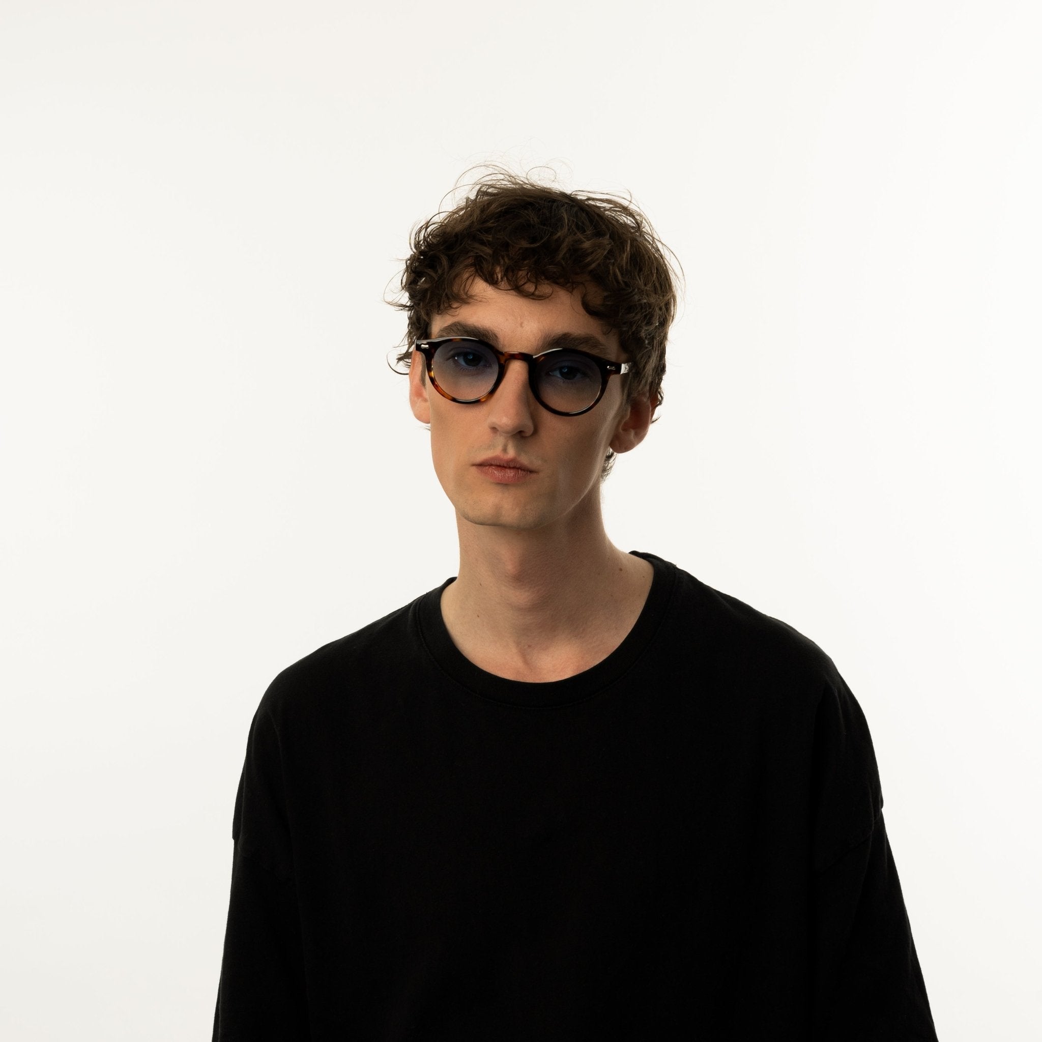 Unisex sunglasses with a round tortoiseshell-patterned frame and blue lenses