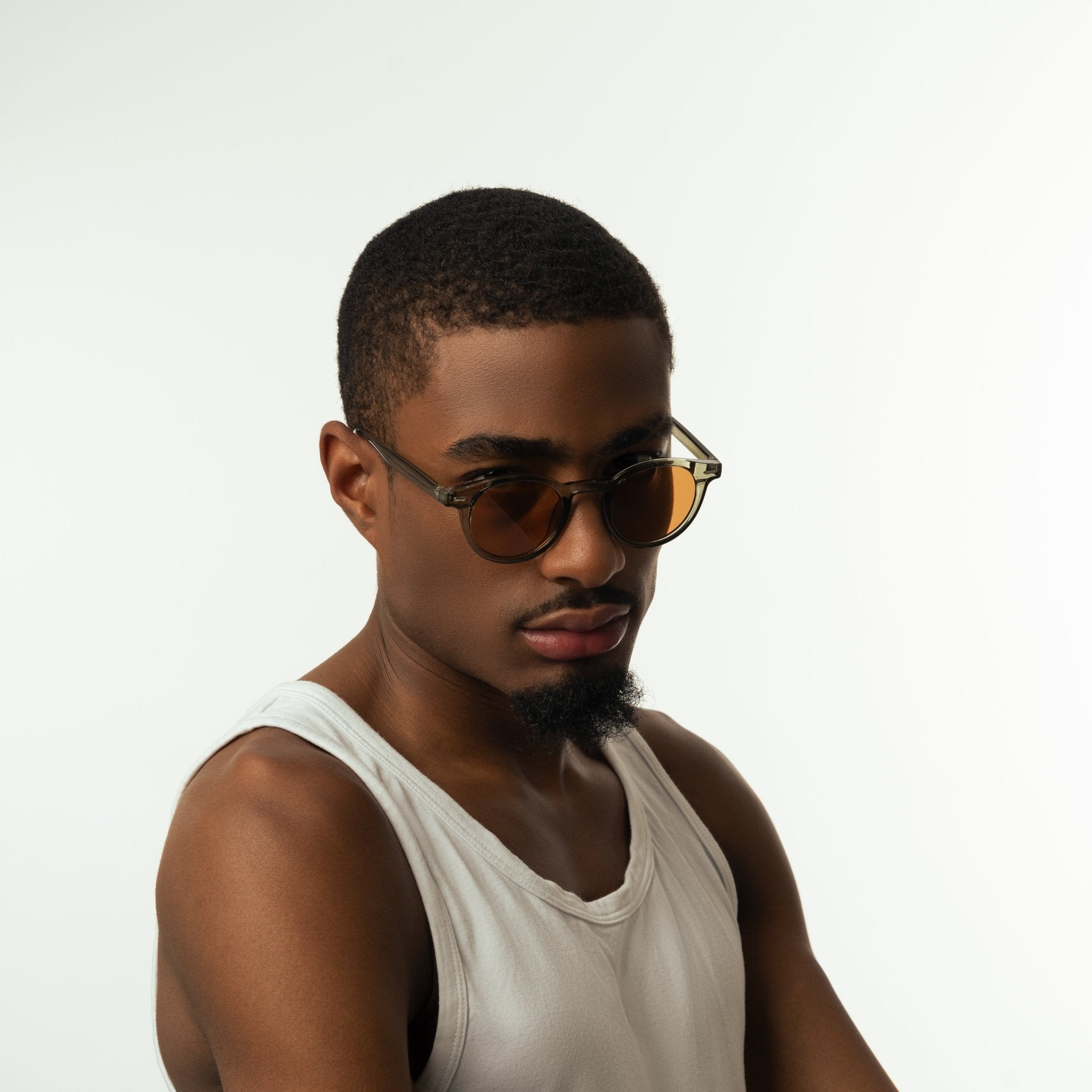 Unisex sunglasses with round brown lenses and an olive frame