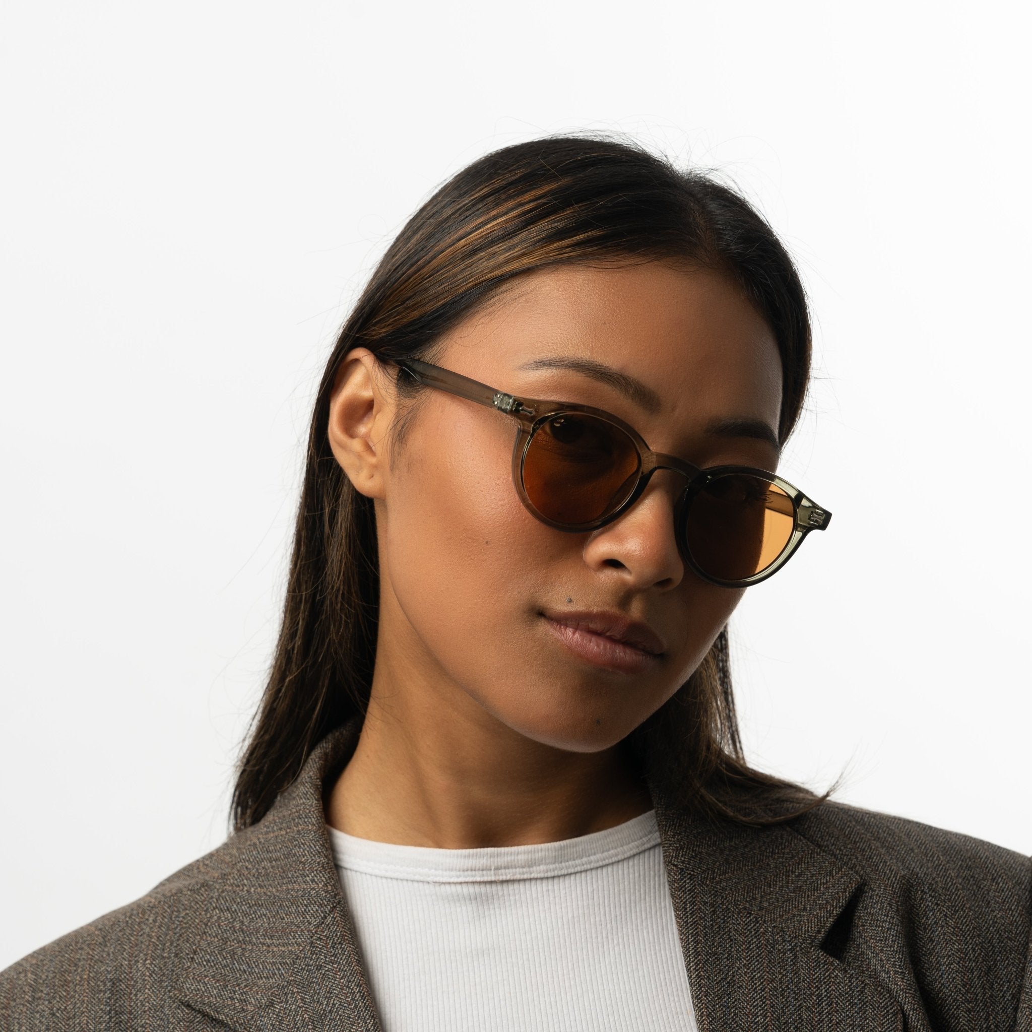 Unisex sunglasses with round brown lenses and an olive frame